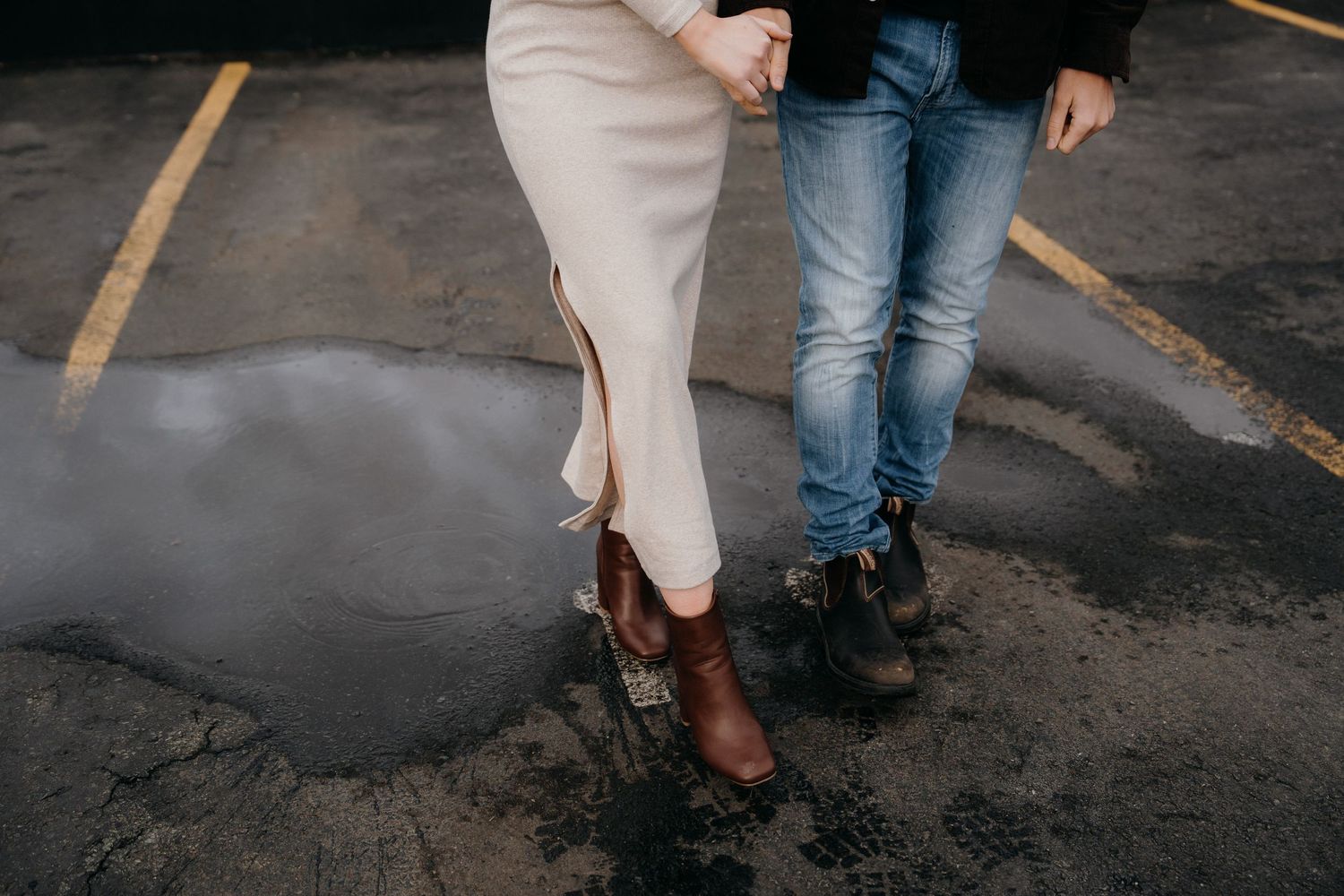 Close-up view of couple's feet and legs during intimate rooftop moment.