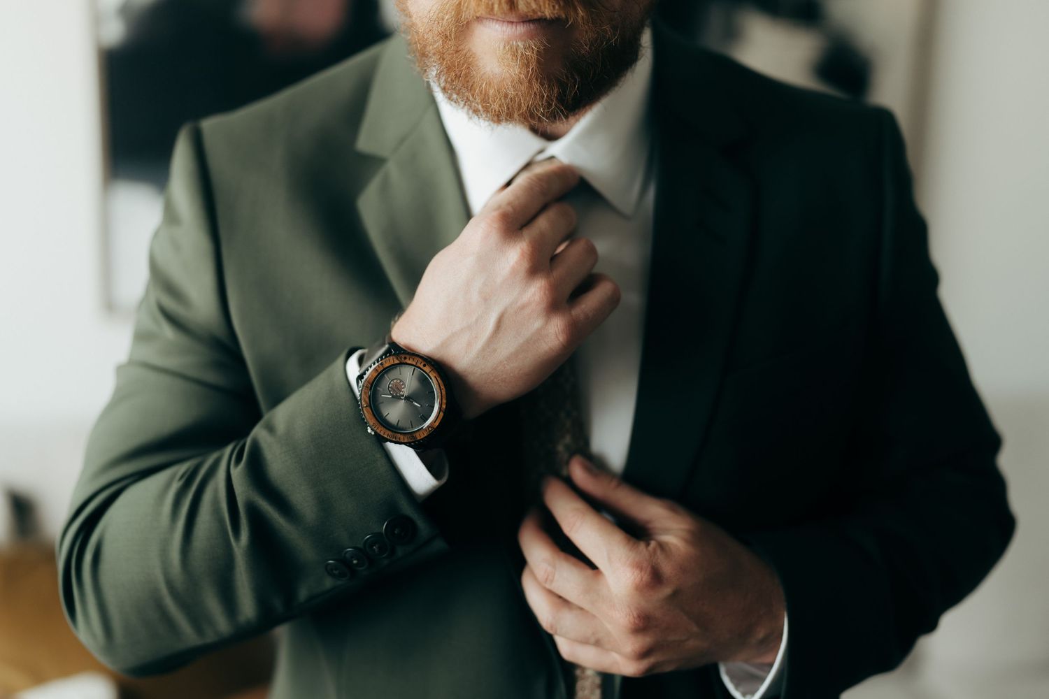 Close-up shots of man adjusting dark suit and tie before event.
