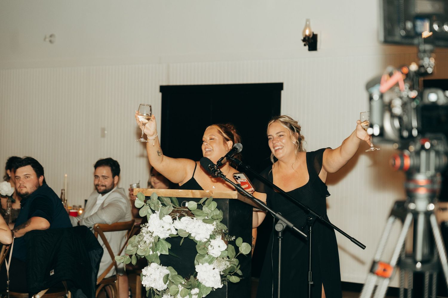 A wedding reception dance party with guests celebrating and dancing together on a dimly lit dance floor.