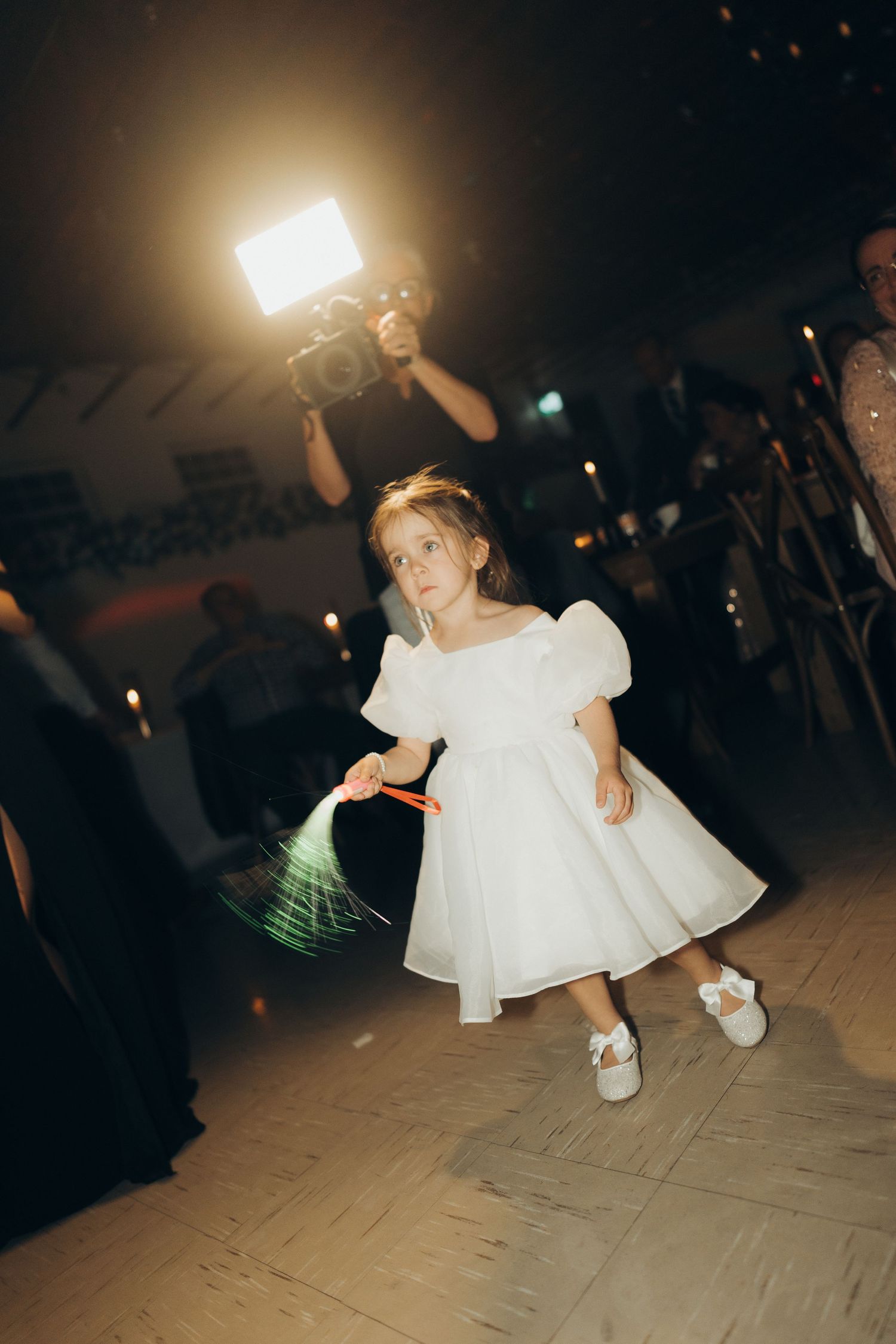 A sequence of dance floor photos showing a person in a white dress twirling and dancing at a dimly lit event.