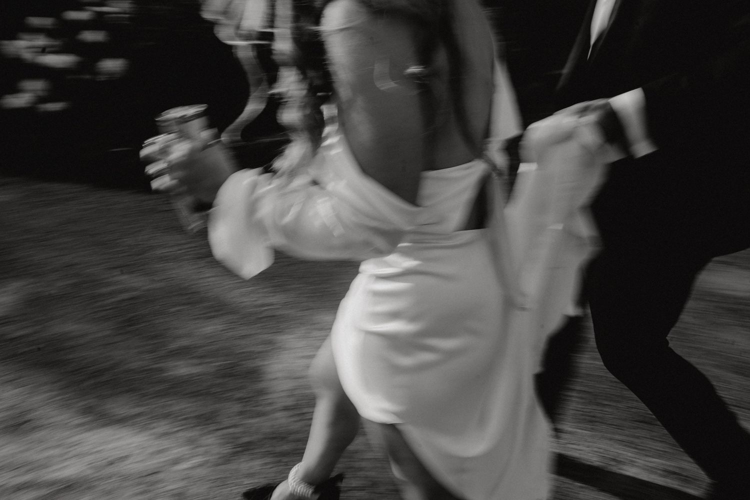 Black and white shot of wedding guests dancing together on the dance floor.