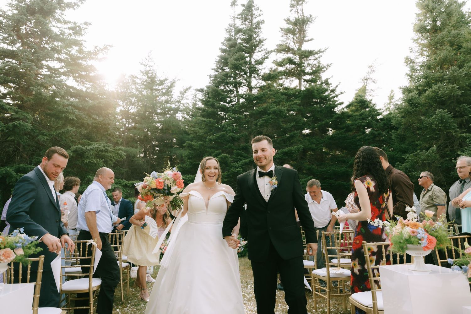 Wedding ceremony in progress at an outdoor forest venue with natural lighting.