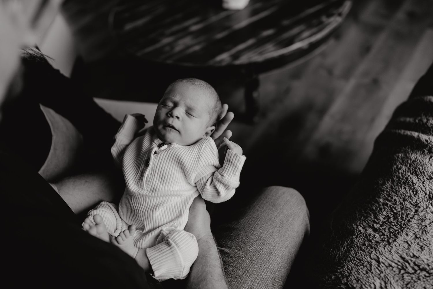 Artistic black and white portraits of family cuddles with newborn baby.