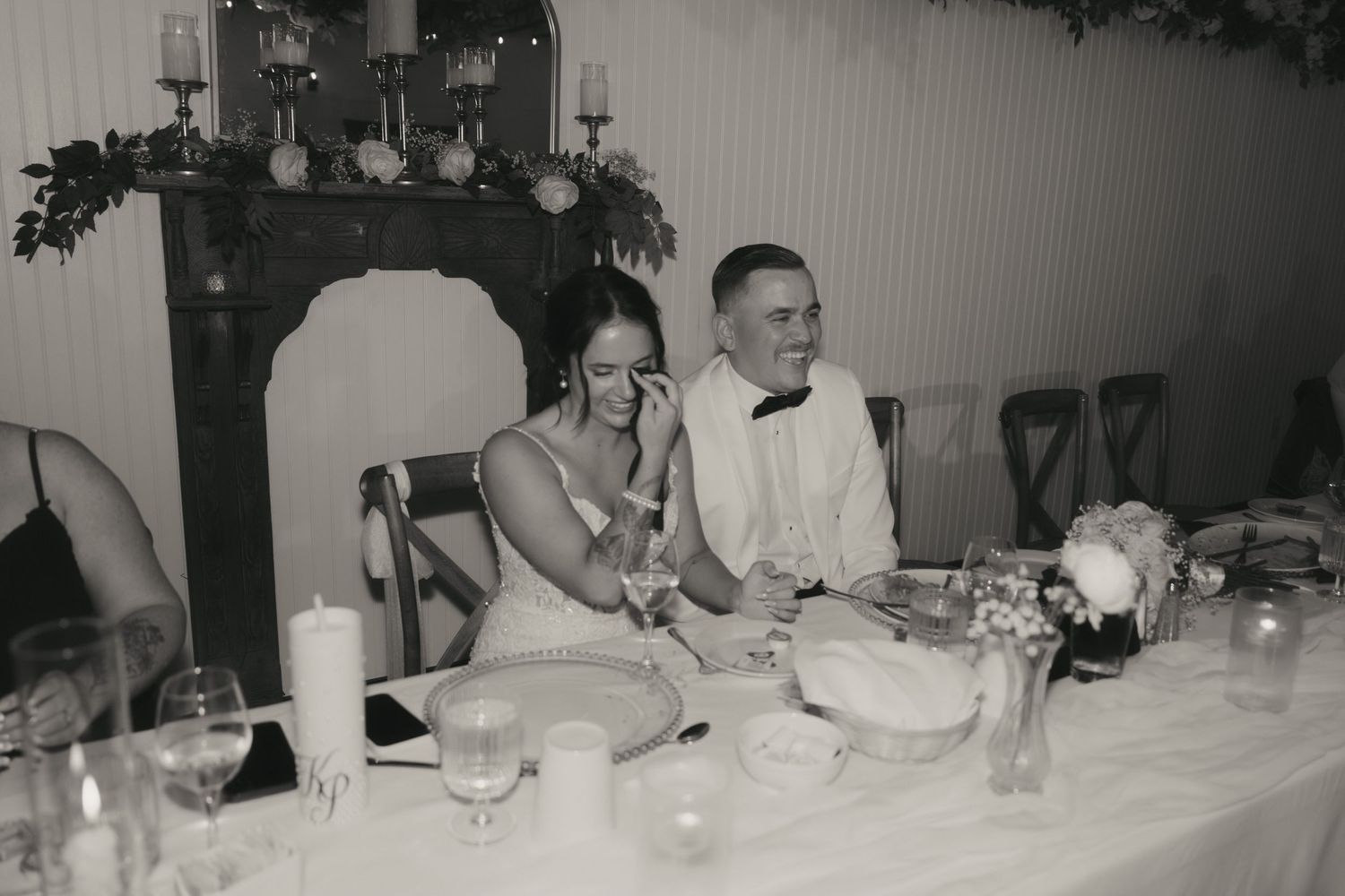 A vintage black and white photograph shows a long dining table set for a formal banquet with multiple guests seated.