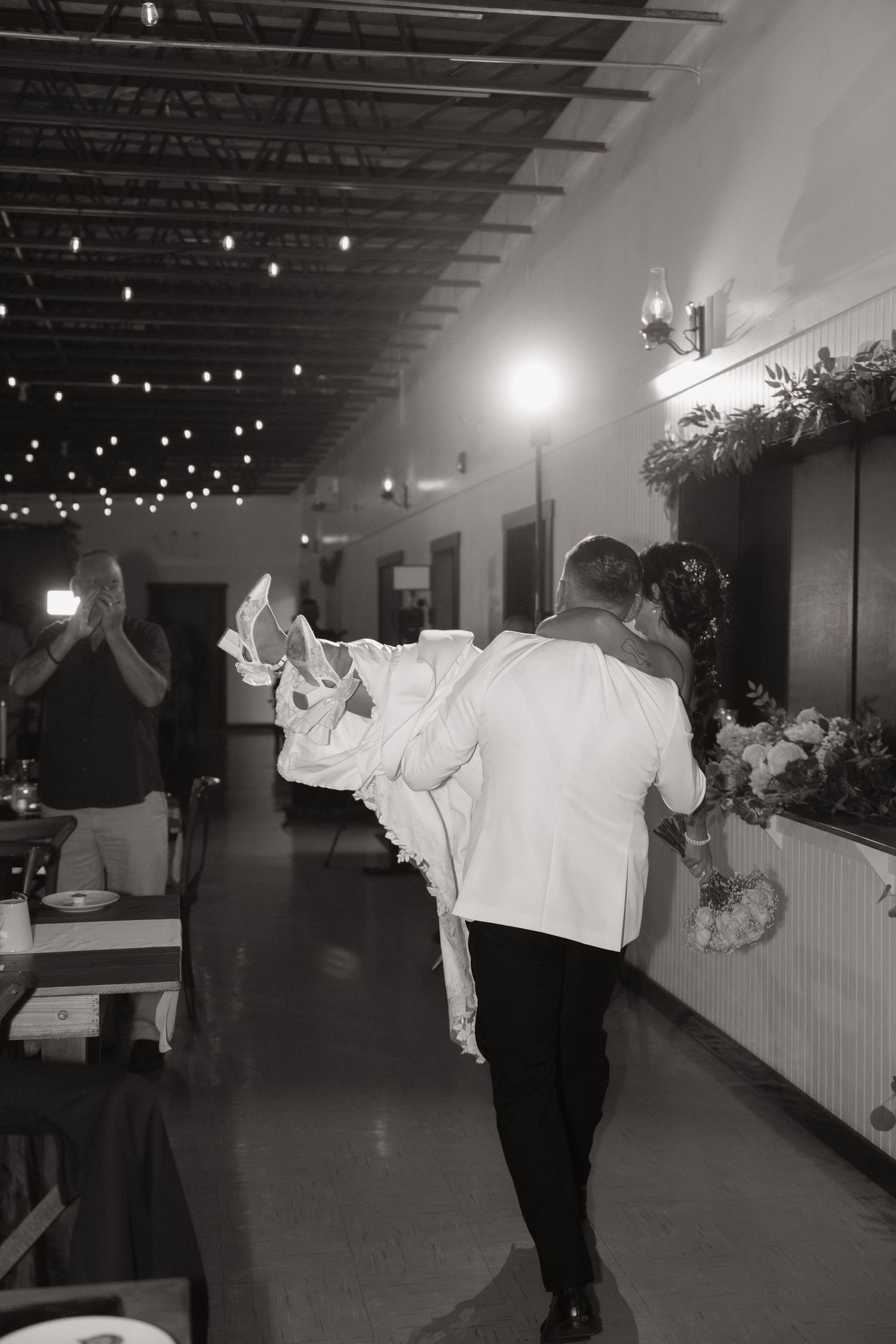 A sequence of black and white photos showing couples dancing together in an indoor venue with string lights overhead.