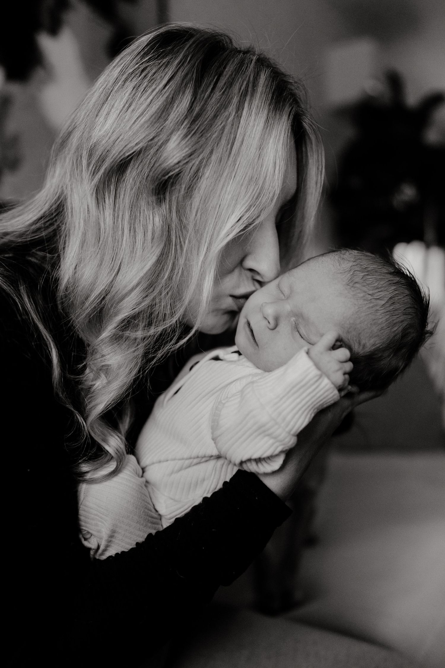 Intimate black and white portrait showing tender moments with a newborn.
