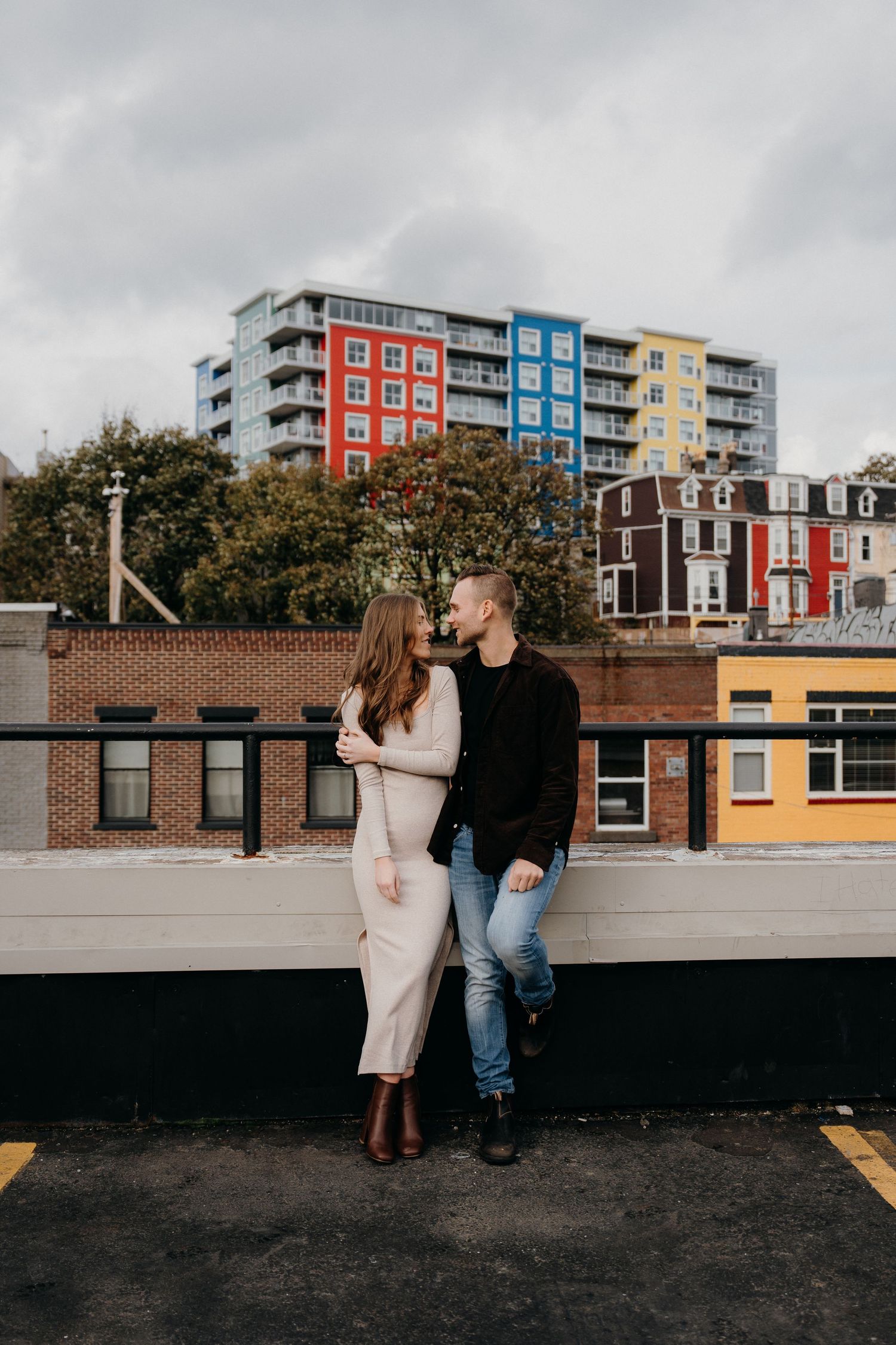 Urban photography session with colorful architecture and brick buildings in background.