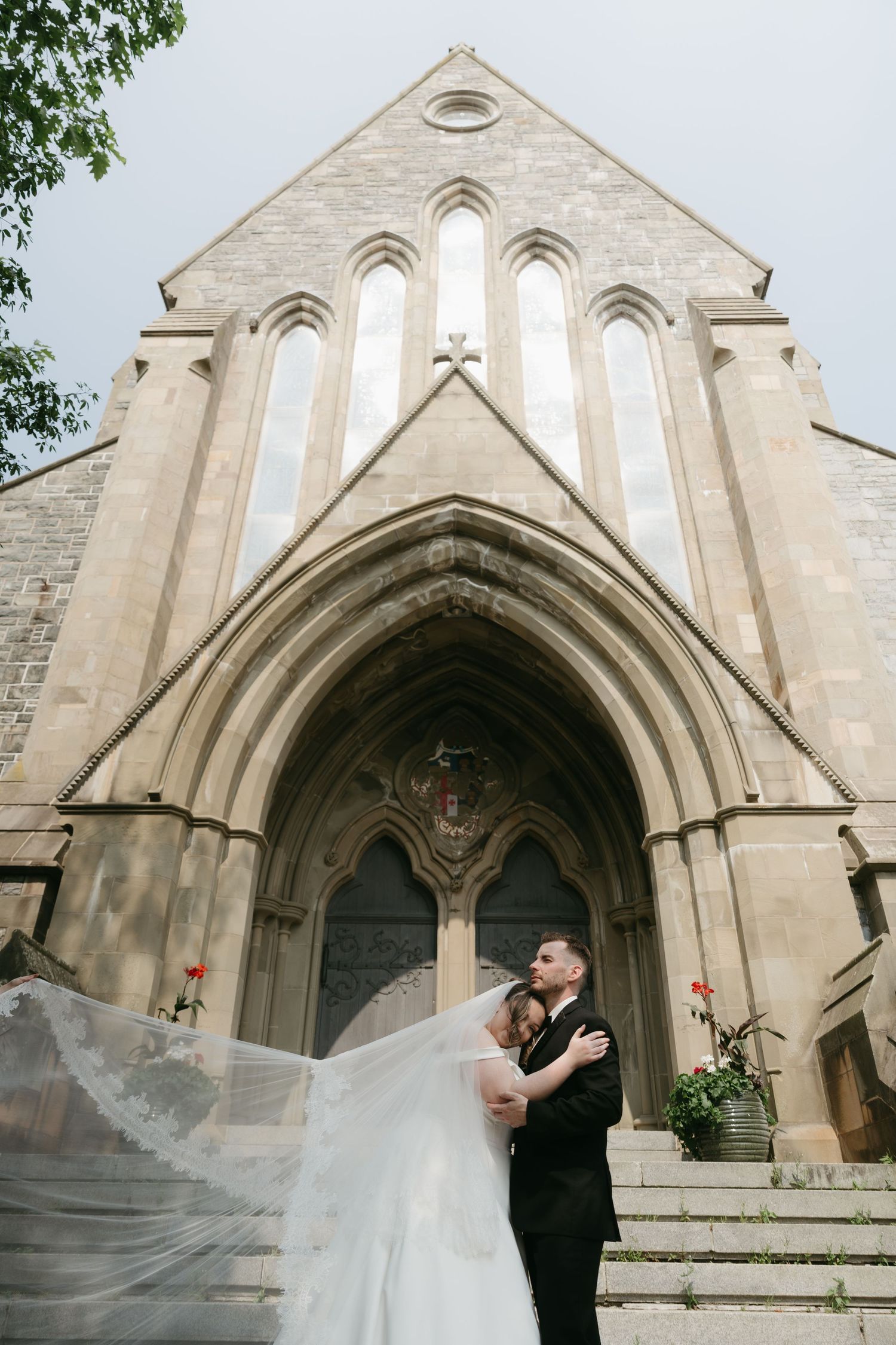 A sequence of romantic wedding photos showing a flowing veil in front of a Gothic church entrance.