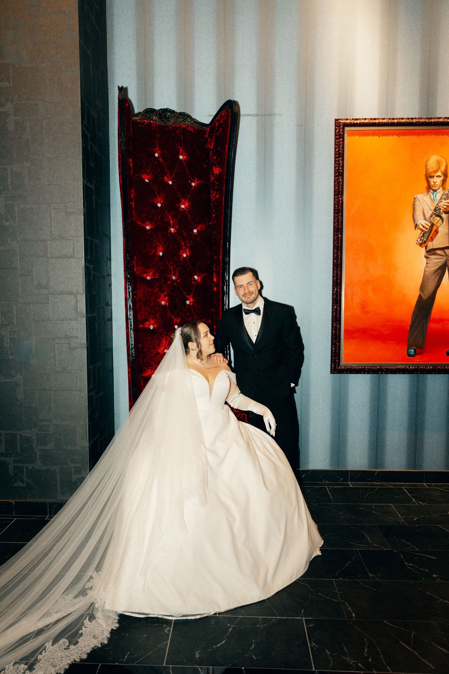 Modern wedding portraits showcasing bride's flowing dress against industrial chic setting.