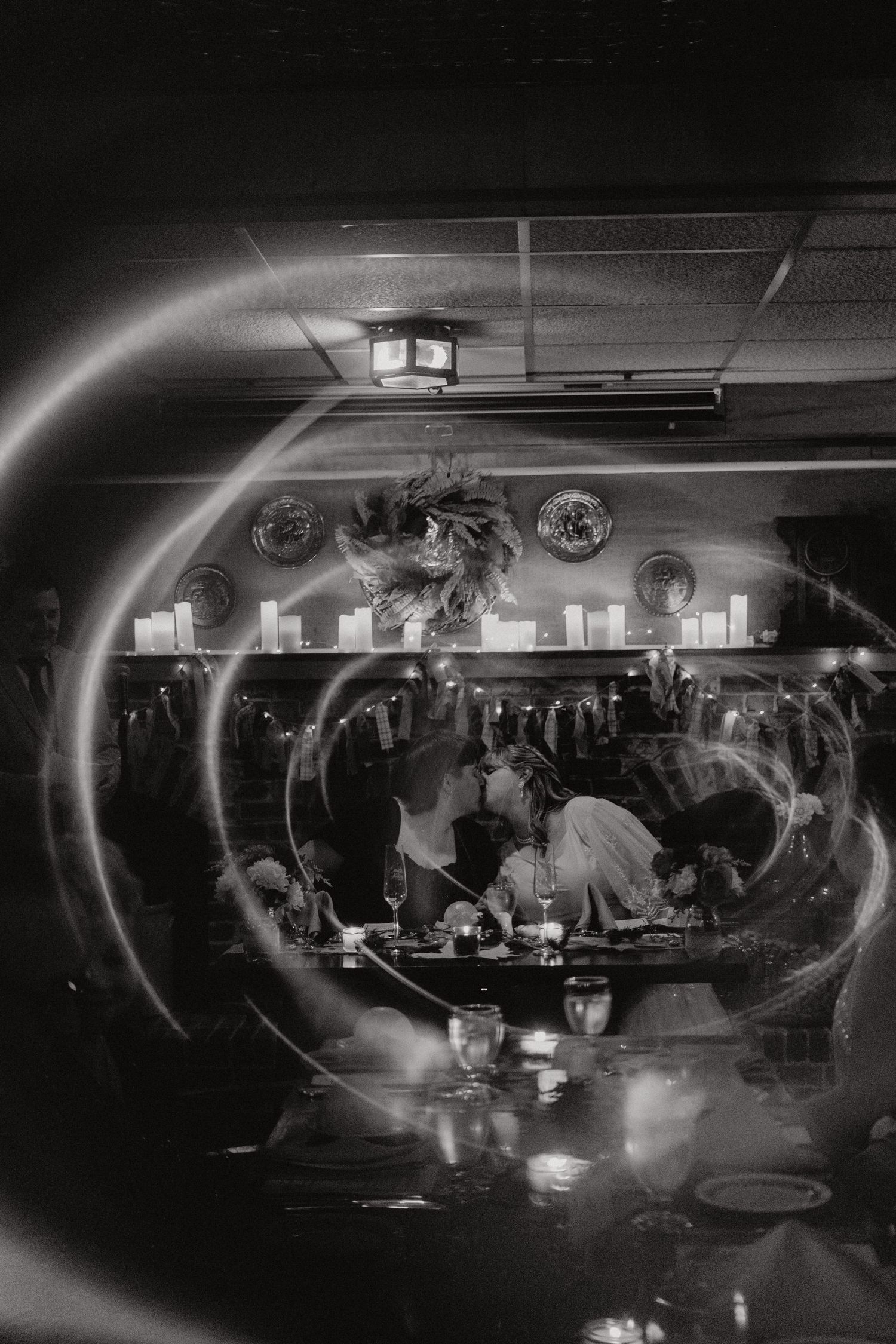 Reception venue with moody lighting and dancing guests captured in panoramic black and white sequence.