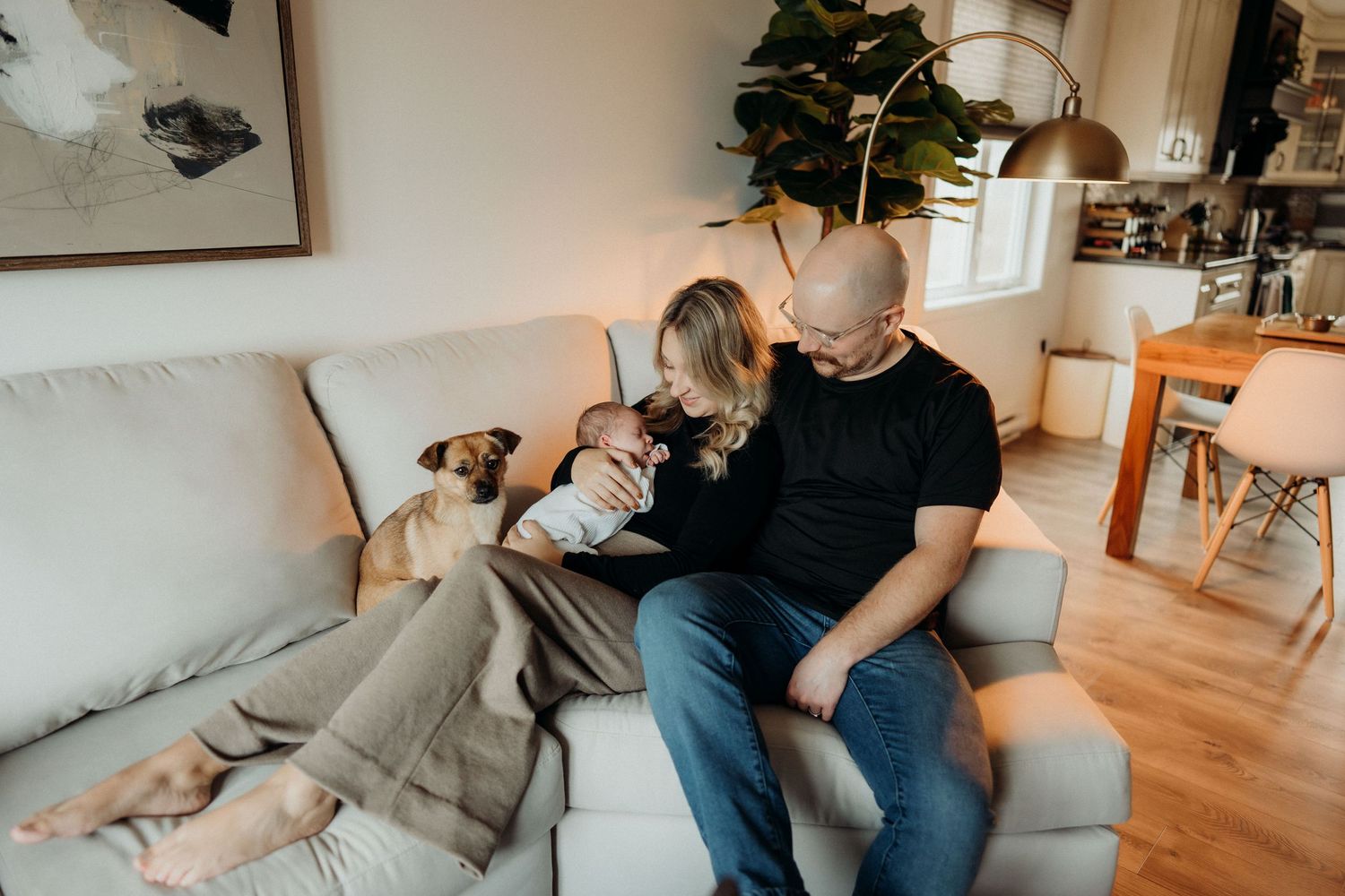 A peaceful living room scene with natural light showing family members and pet relaxing.