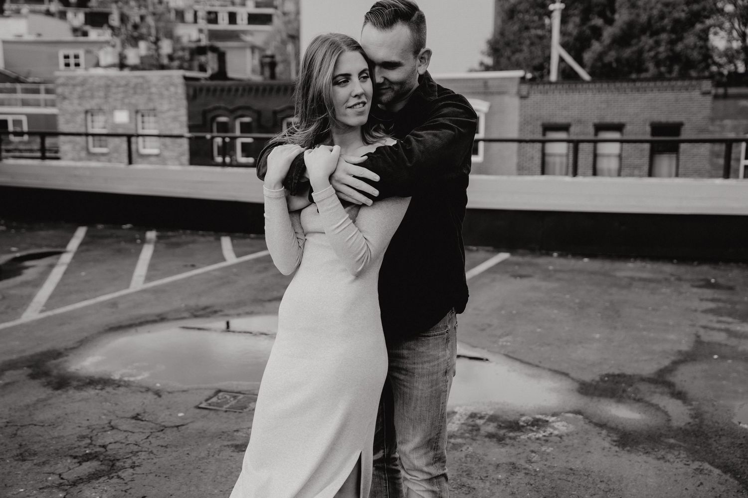 Urban rooftop engagement session featuring couple's candid interactions.