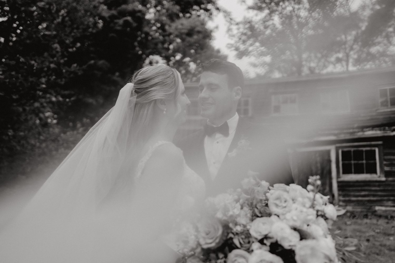 Black and white wedding portrait taken outdoors with natural lighting.