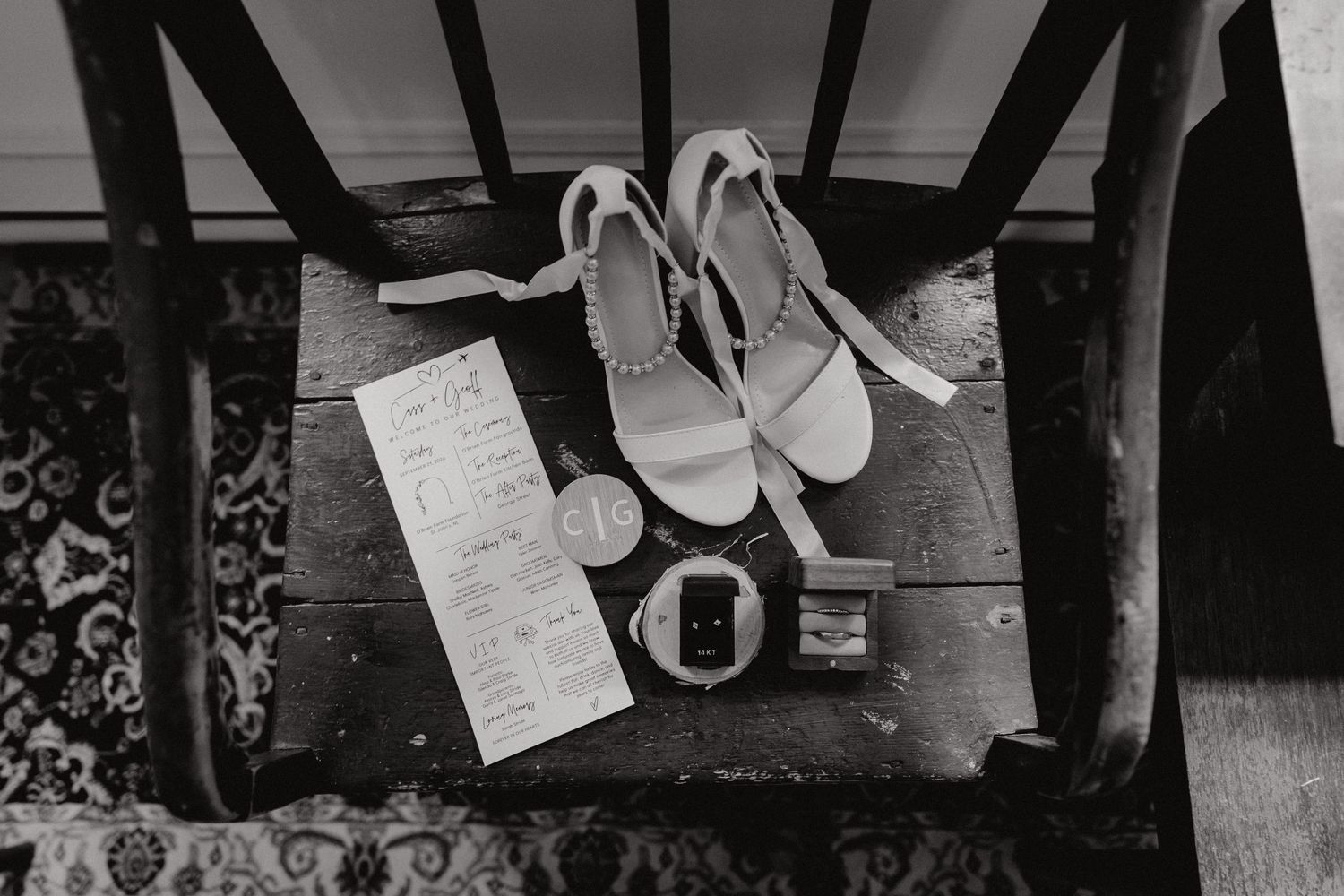 Wedding shoes and boots arranged on a dark wooden floor with window light creating dramatic shadows.