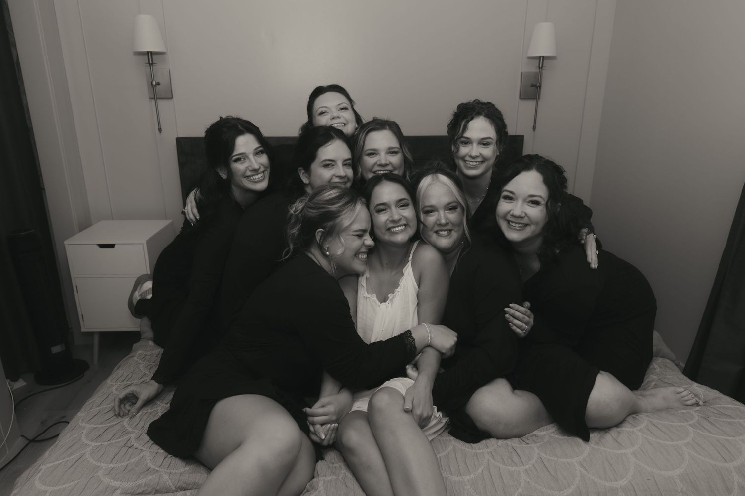 A group of friends laugh and smile together while laying down in a casual setting.