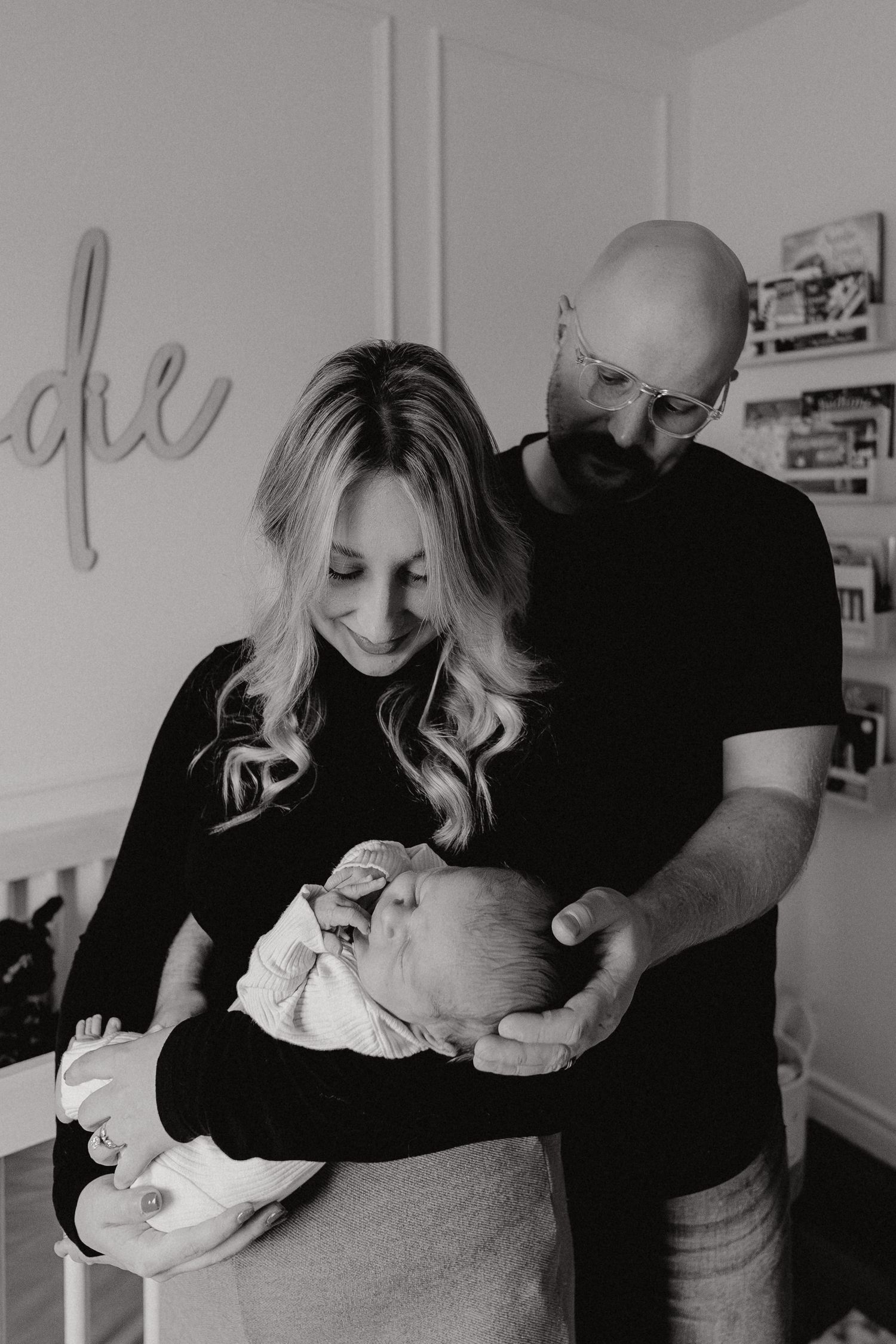Intimate black and white photograph showing tender moments in a bright interior setting.
