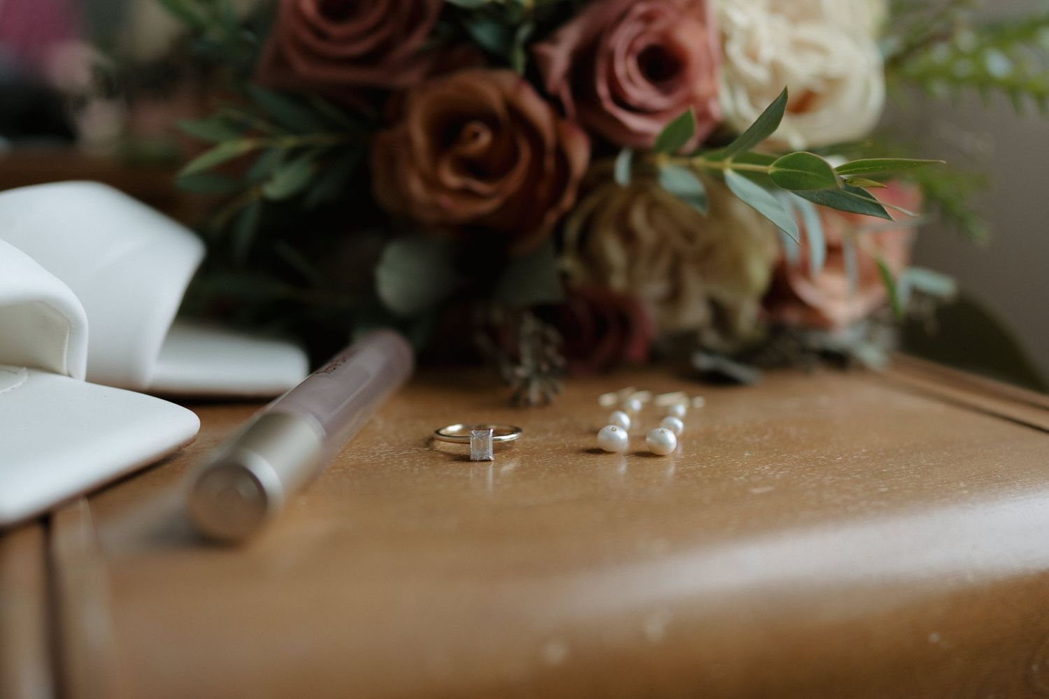 A collection of wedding detail shots showing rings, flowers, and decor arranged in a romantic style.