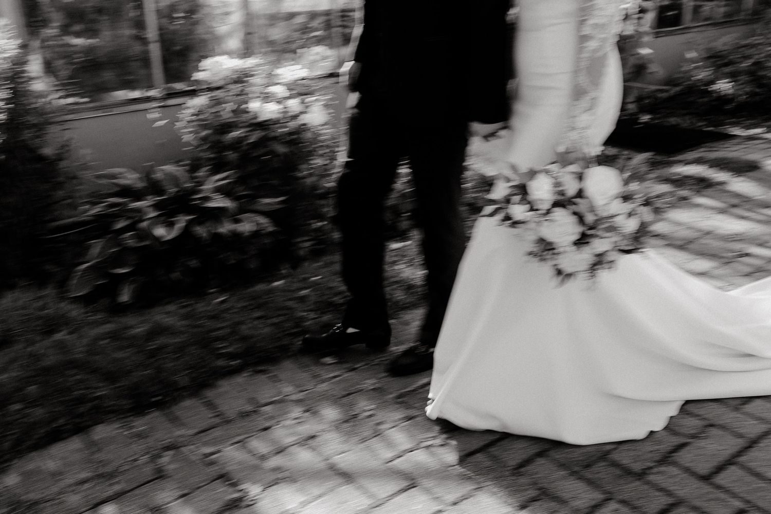 Black and white wedding scene captured on vintage brick walkway.