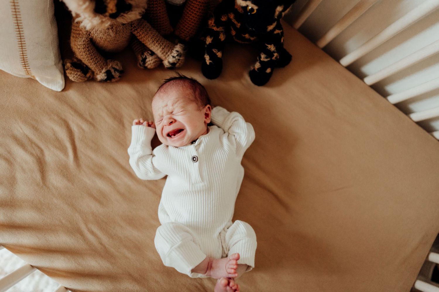 Lifestyle photography of tender family moments on soft bedding in natural light.