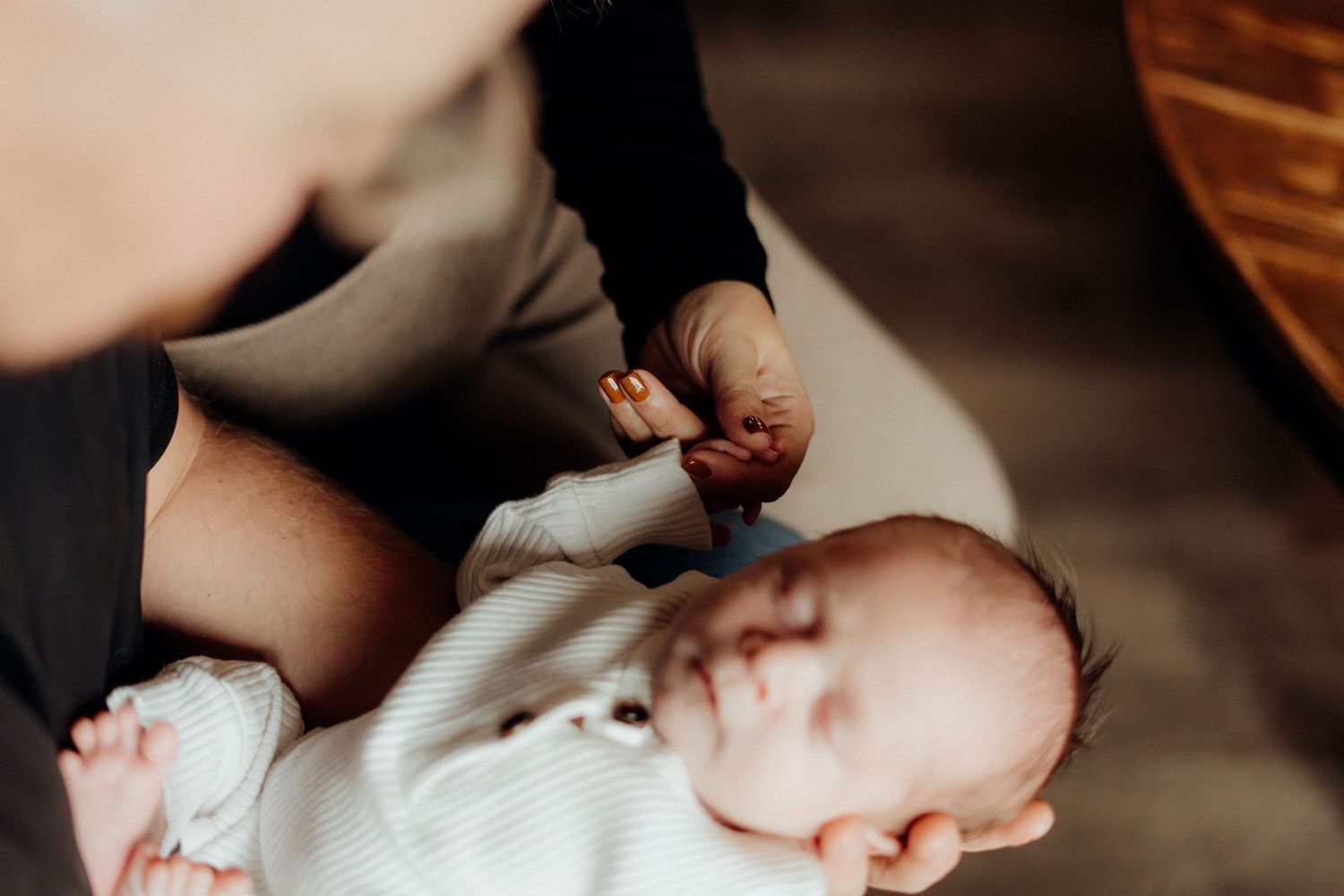 Close-up lifestyle photograph of gentle family moments in warm ambient lighting.
