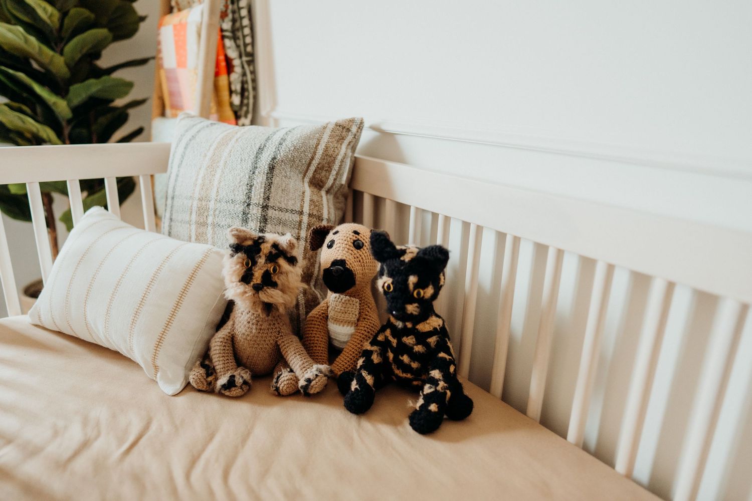 Cozy nursery corner with stuffed animals and white crib railing.