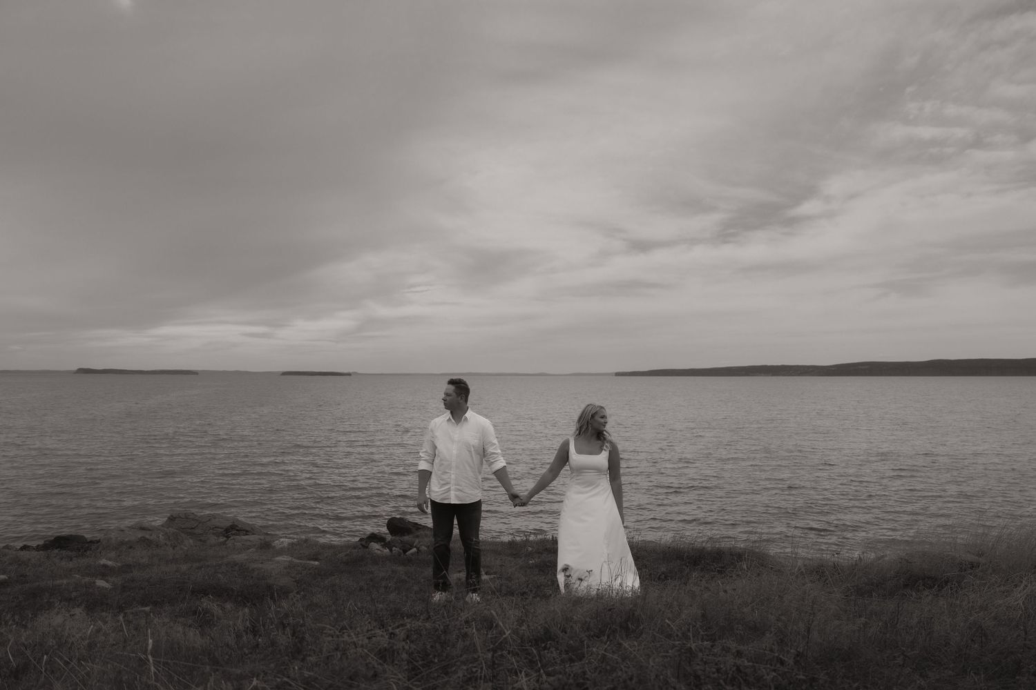 A series of black and white landscape photographs showing coastal scenes with moody skies and ocean views.