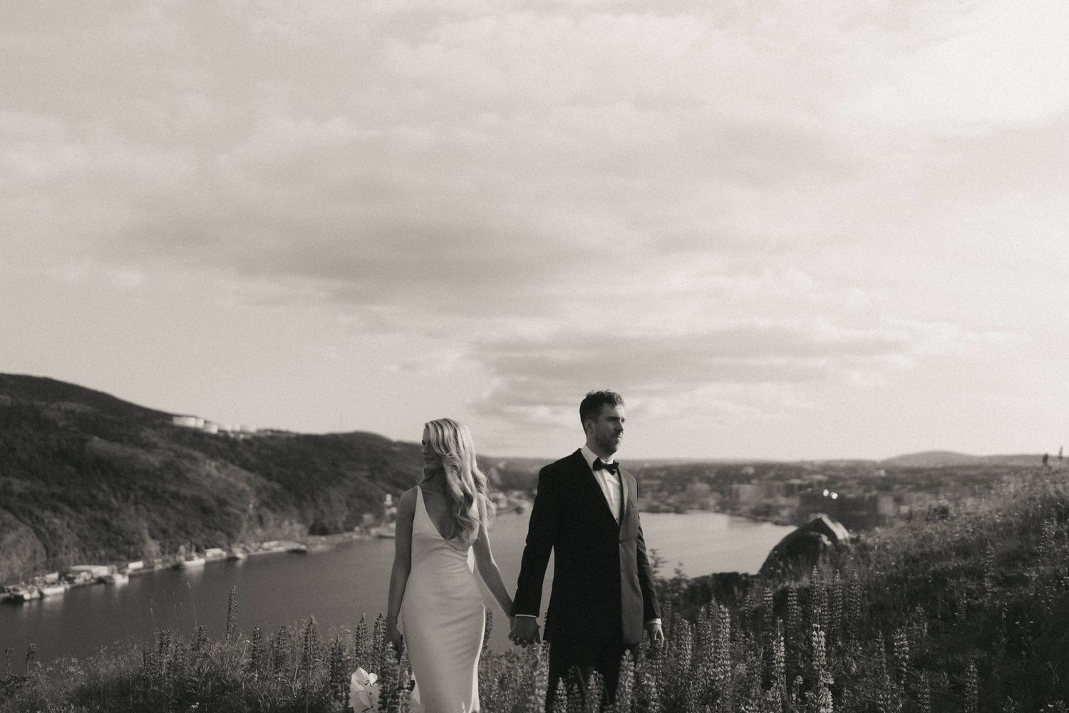 Dramatic panoramic coastal landscape serves as backdrop for wedding photography.