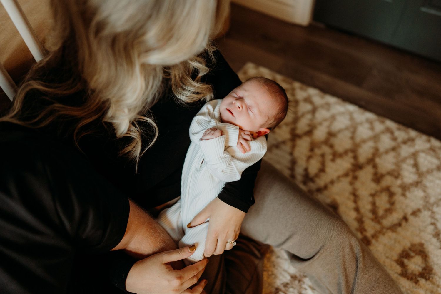 Intimate nursery scene with soft natural lighting and patterned carpet.