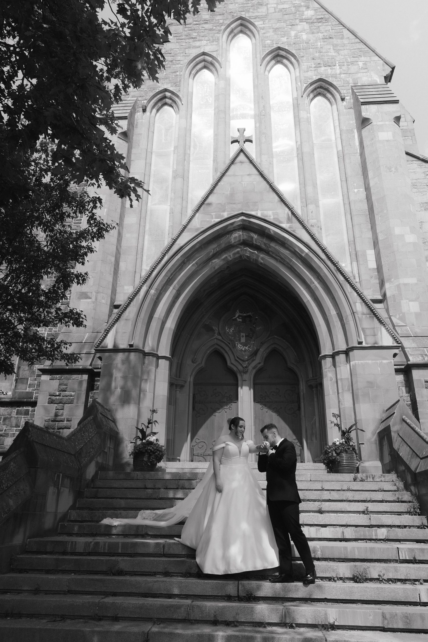 A wedding ceremony unfolds on the stone steps of a Gothic church entrance.