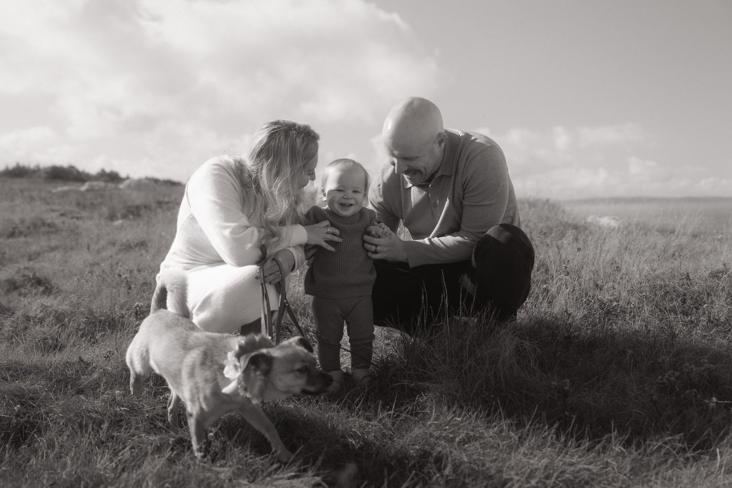 A series of black and white landscape photographs showing people sitting on a grassy hillside.