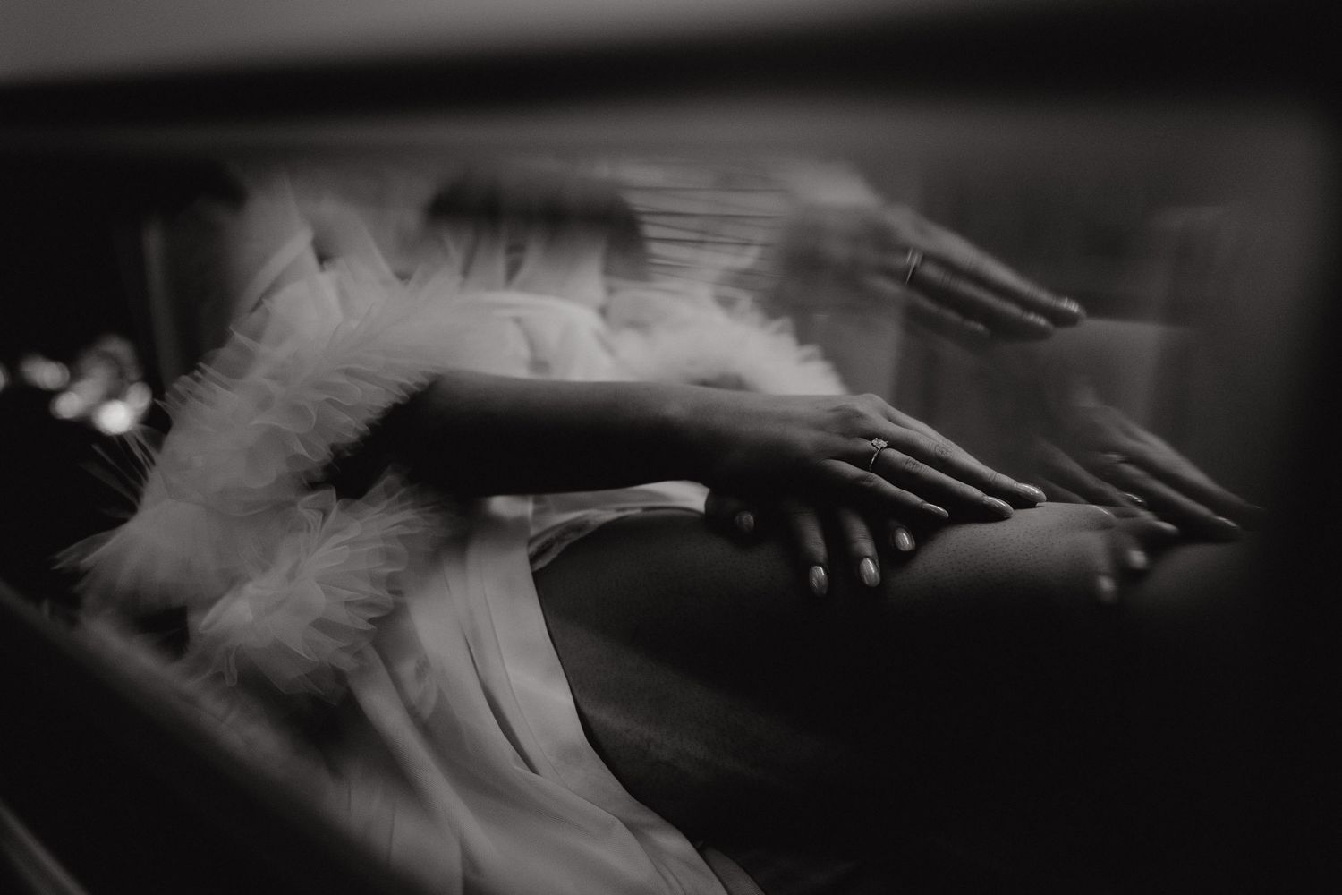 Artistic black and white close-up of hands moving across piano keys.