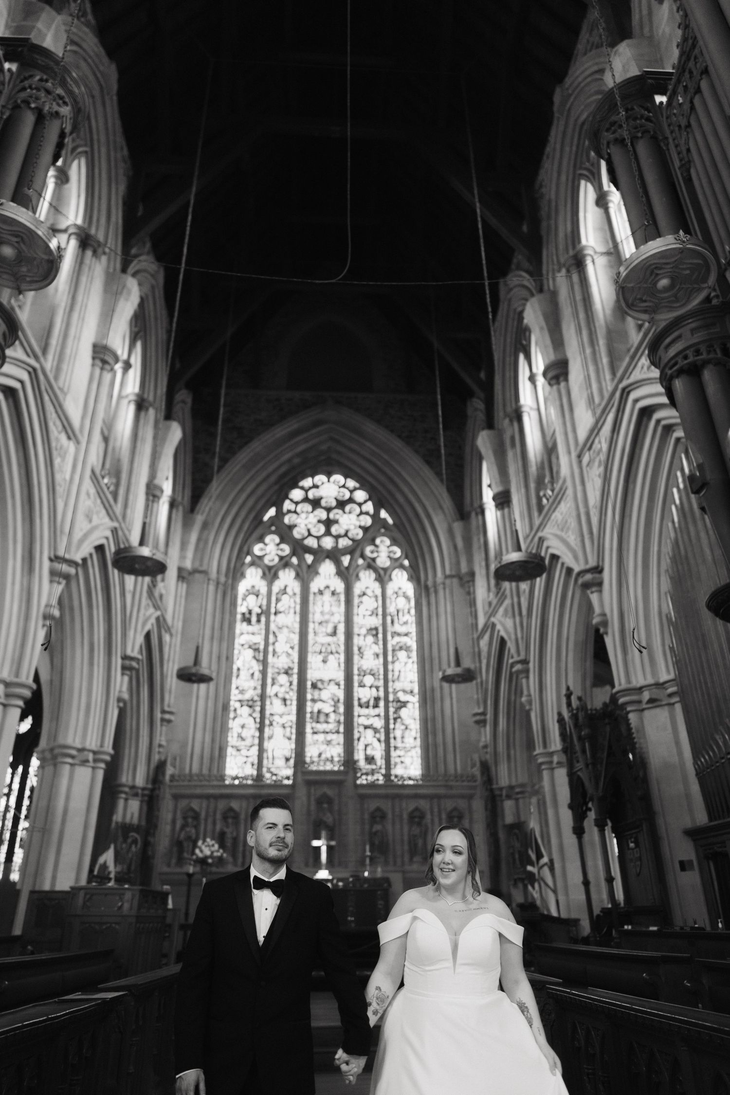 Black and white photo of a cathedral interior with dramatic lighting and gothic architecture.