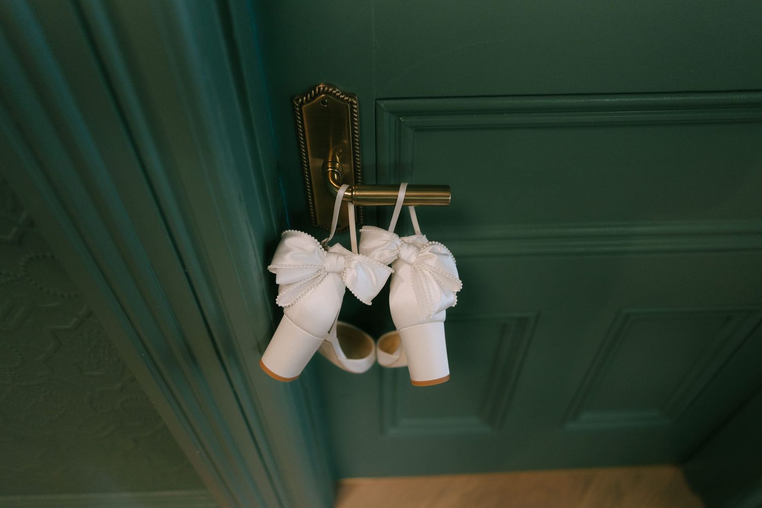 Wedding dress details captured in moody green-toned lighting.