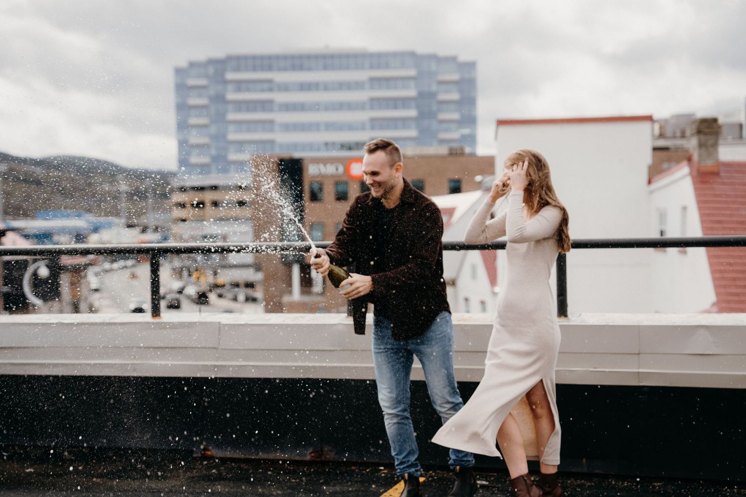 A romantic rooftop scene unfolds between two people with urban buildings in the background.