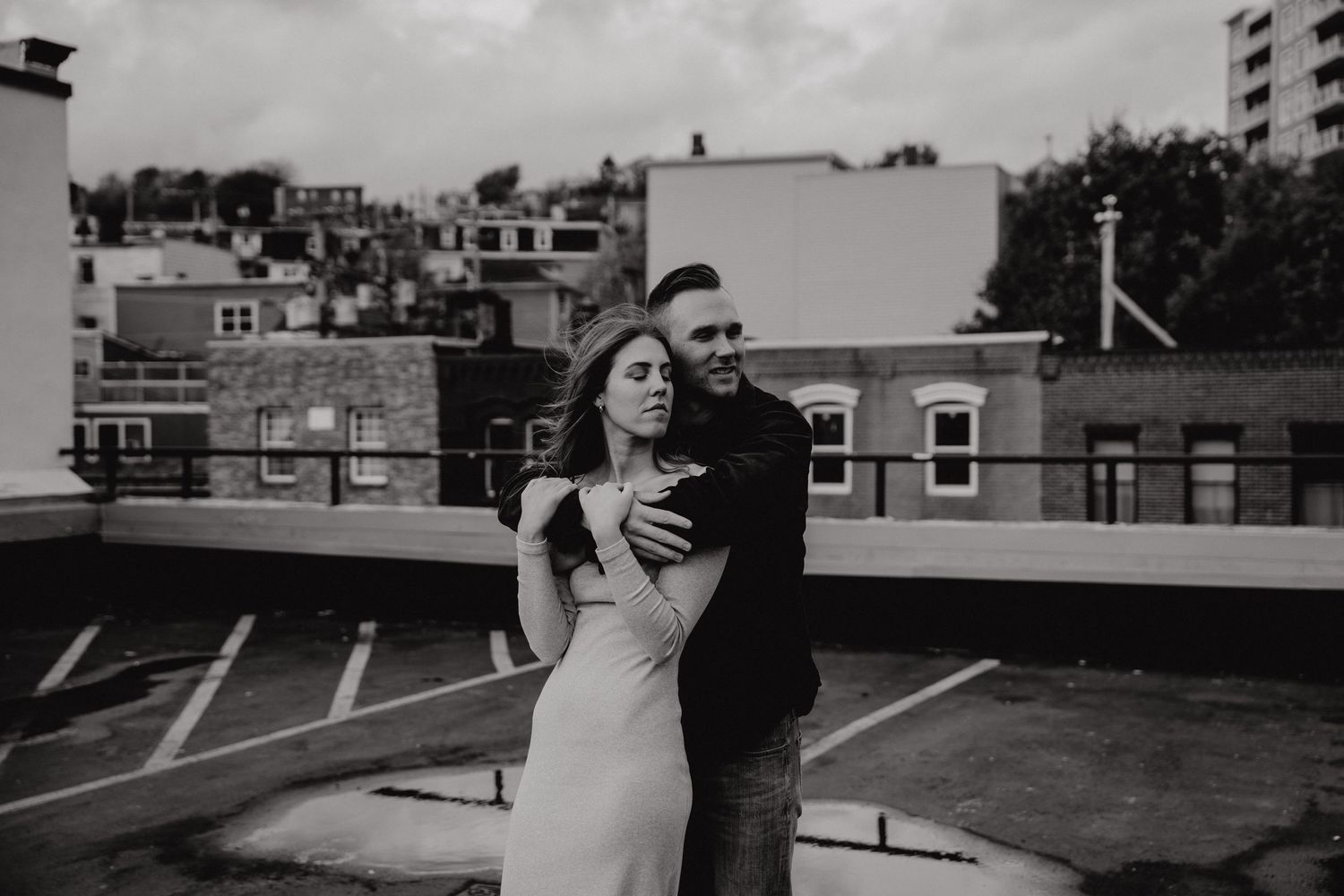 Black and white cityscape serves as backdrop for a romantic couple's photoshoot.