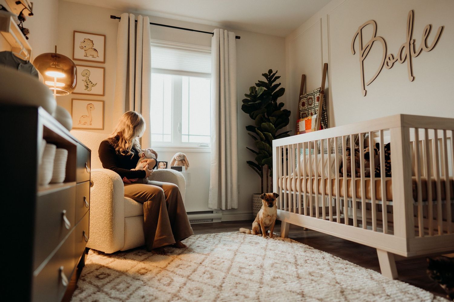 Stylish nursery interior with script wall art and white furniture.