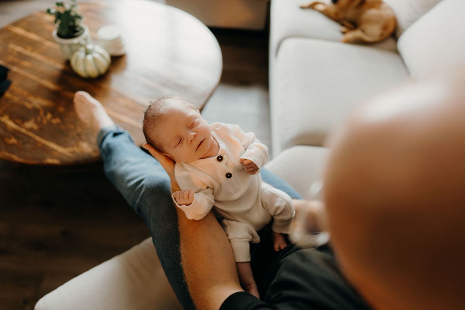 Intimate moment showing a baby in white clothing resting peacefully.