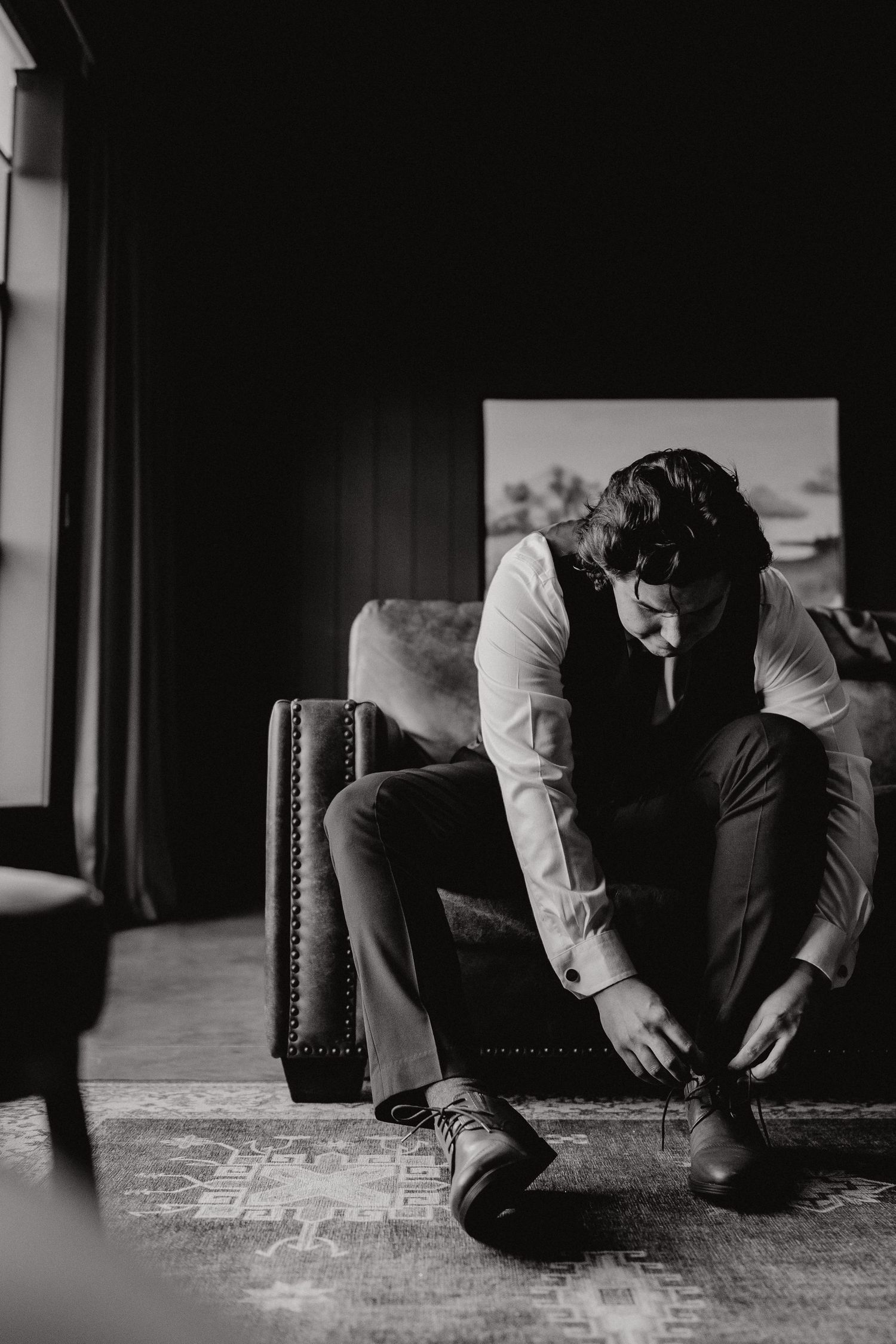 Black and white image of formal dress shoes being put on.
