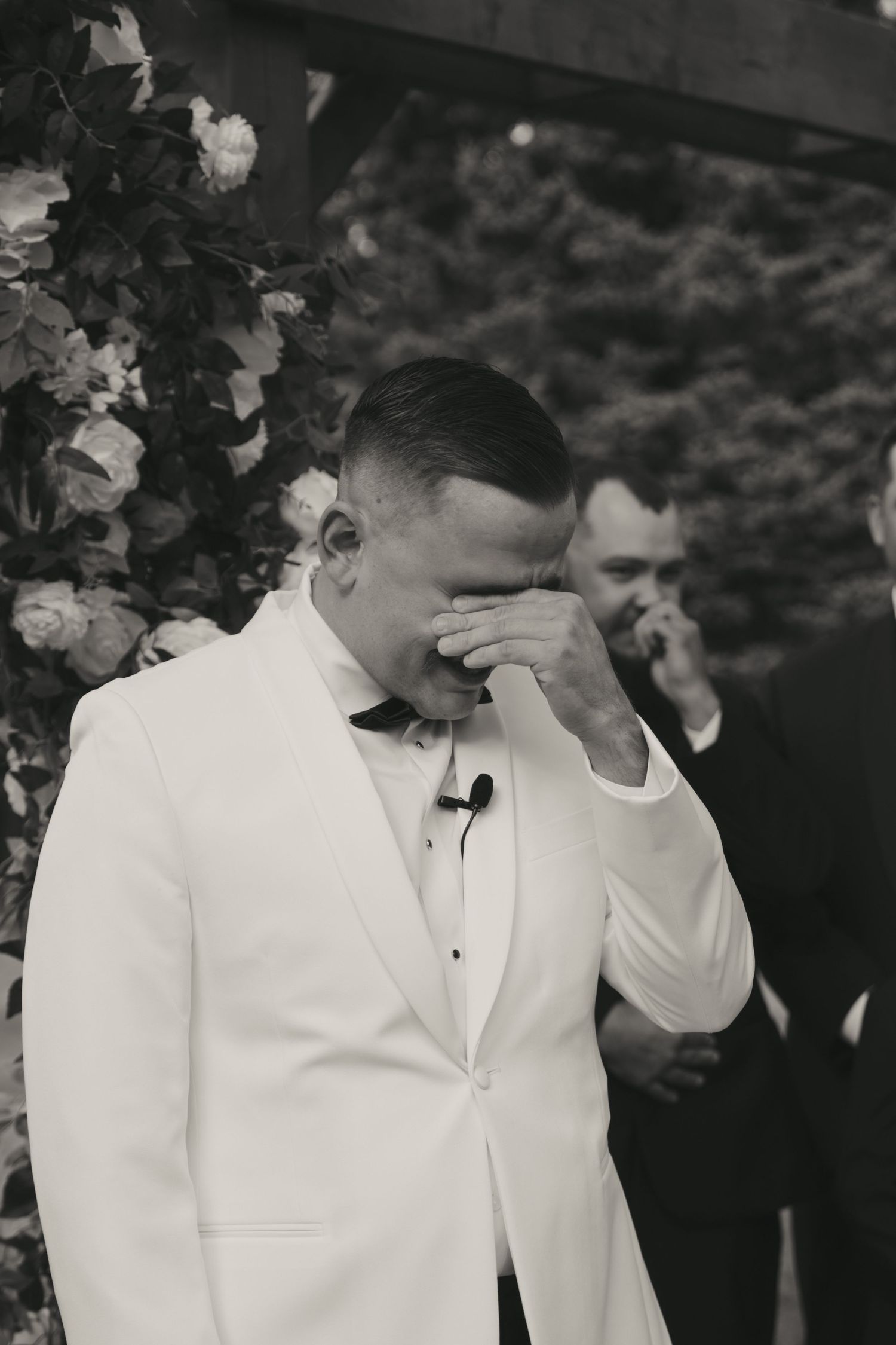 A black and white photo of a couple in formal attire at what appears to be a wedding ceremony.