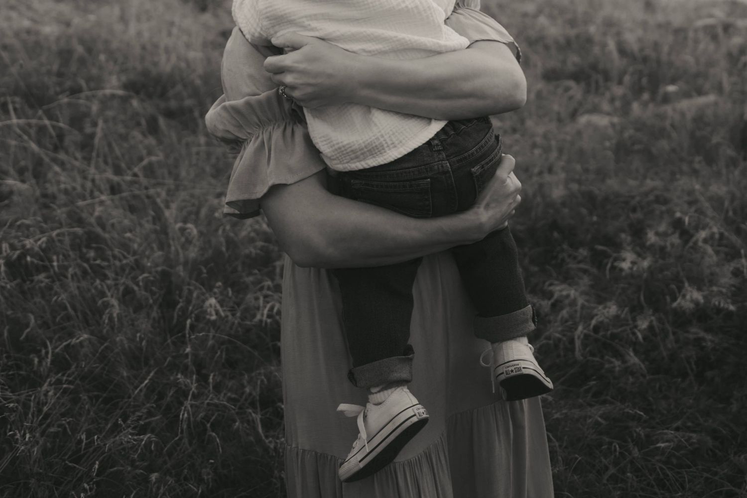 A series of black and white photographs showing cropped views of people embracing in an outdoor setting.