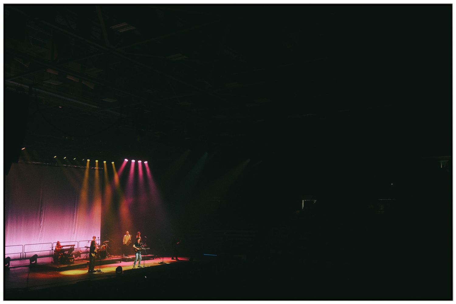 Concert stage illuminated with dramatic red and purple lighting effects during a live performance.