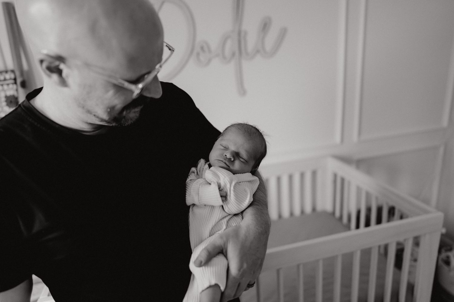 Black and white photographs showing gentle interactions in a nursery setting.