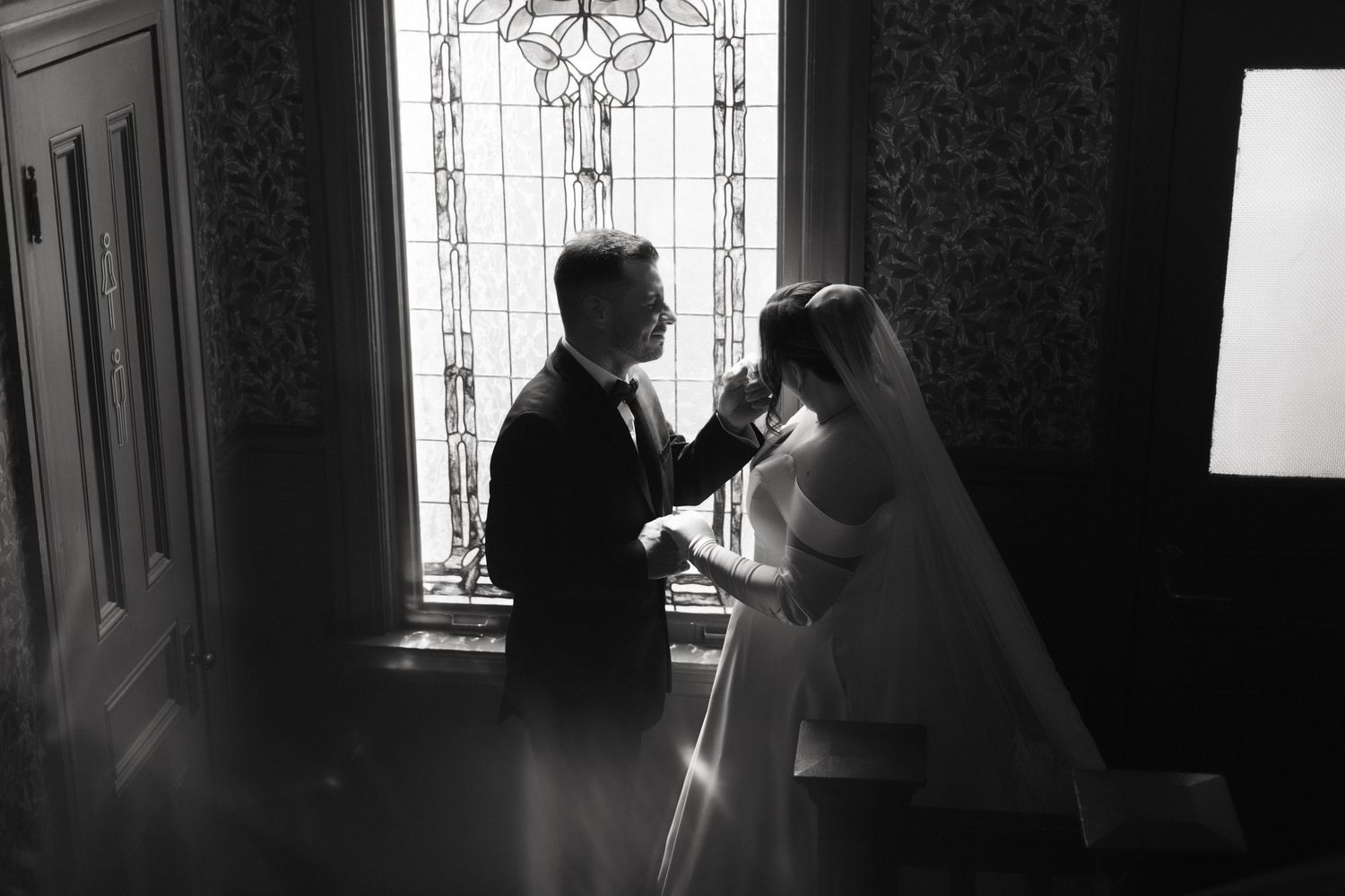 Dramatic silhouettes against stained glass window in black and white.