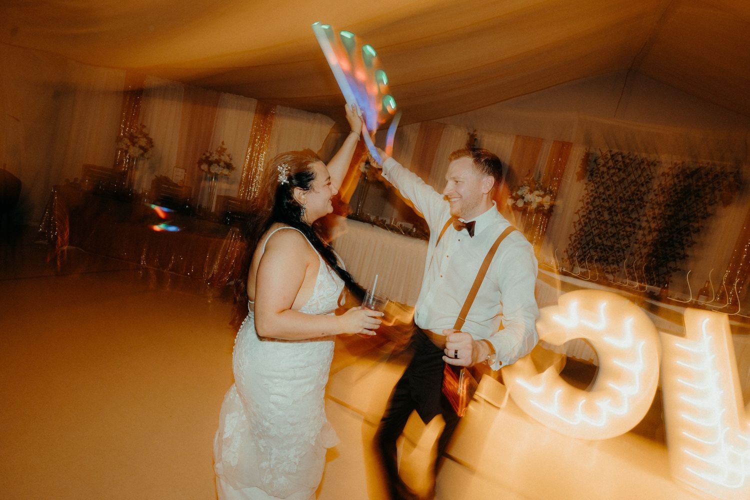 Wedding reception dance party with warm lighting and festive atmosphere.