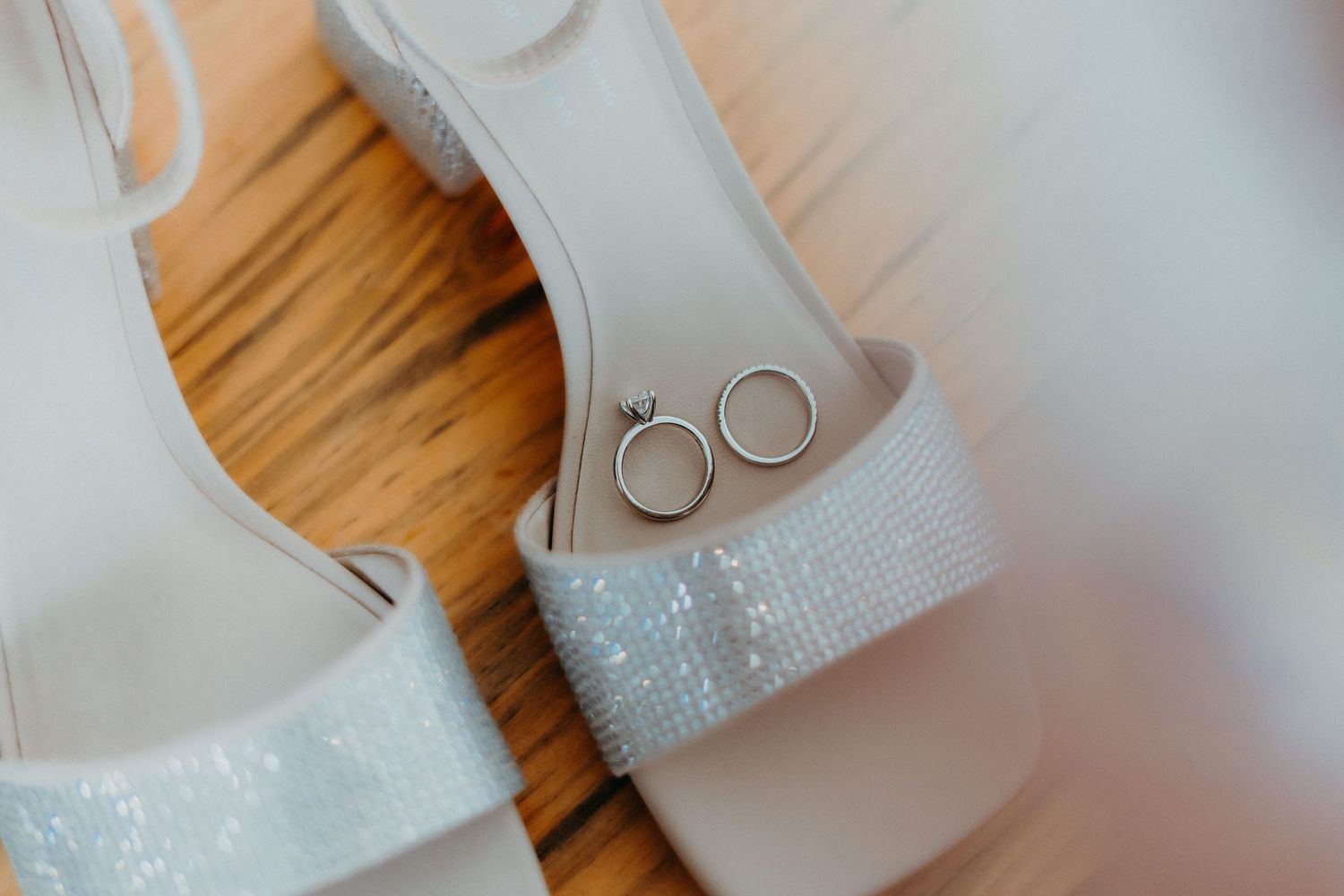 Close-up detail shot of wedding rings on a white lace background.