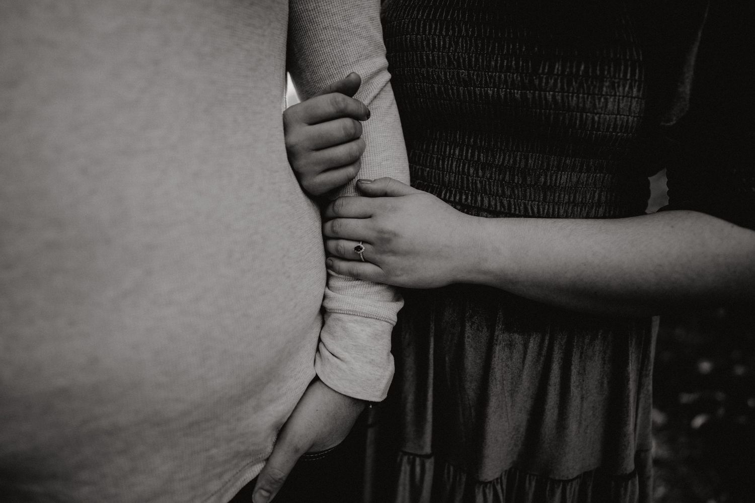 Close-up black and white details of gentle embraces and holding hands.