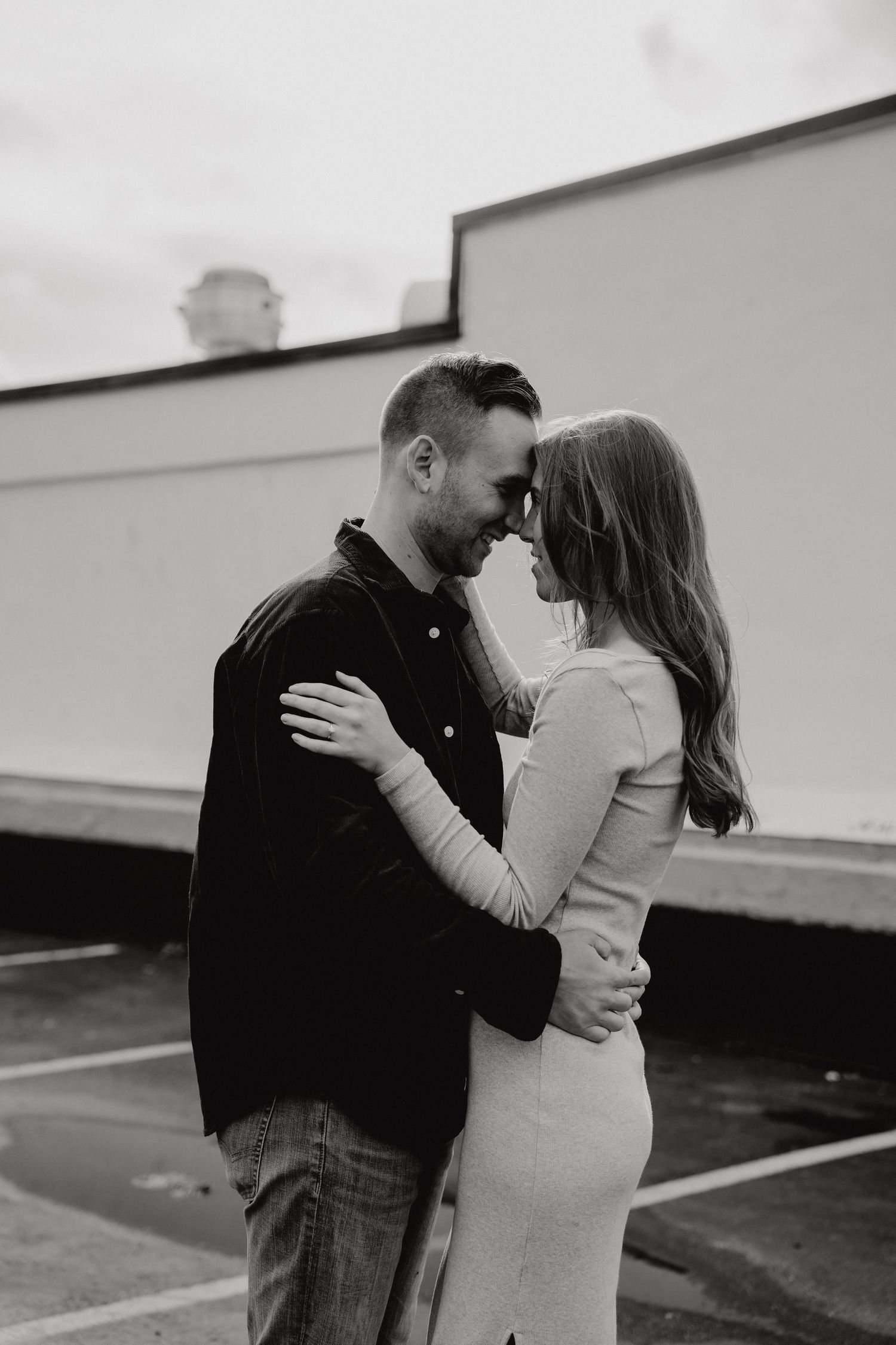 Intimate black and white portrait of a couple sharing a tender moment outdoors.