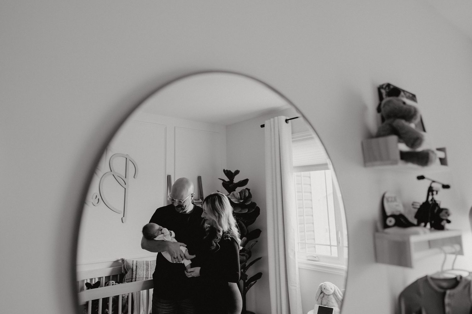 Artistic black and white mirror compositions capturing quiet moments in a nursery.