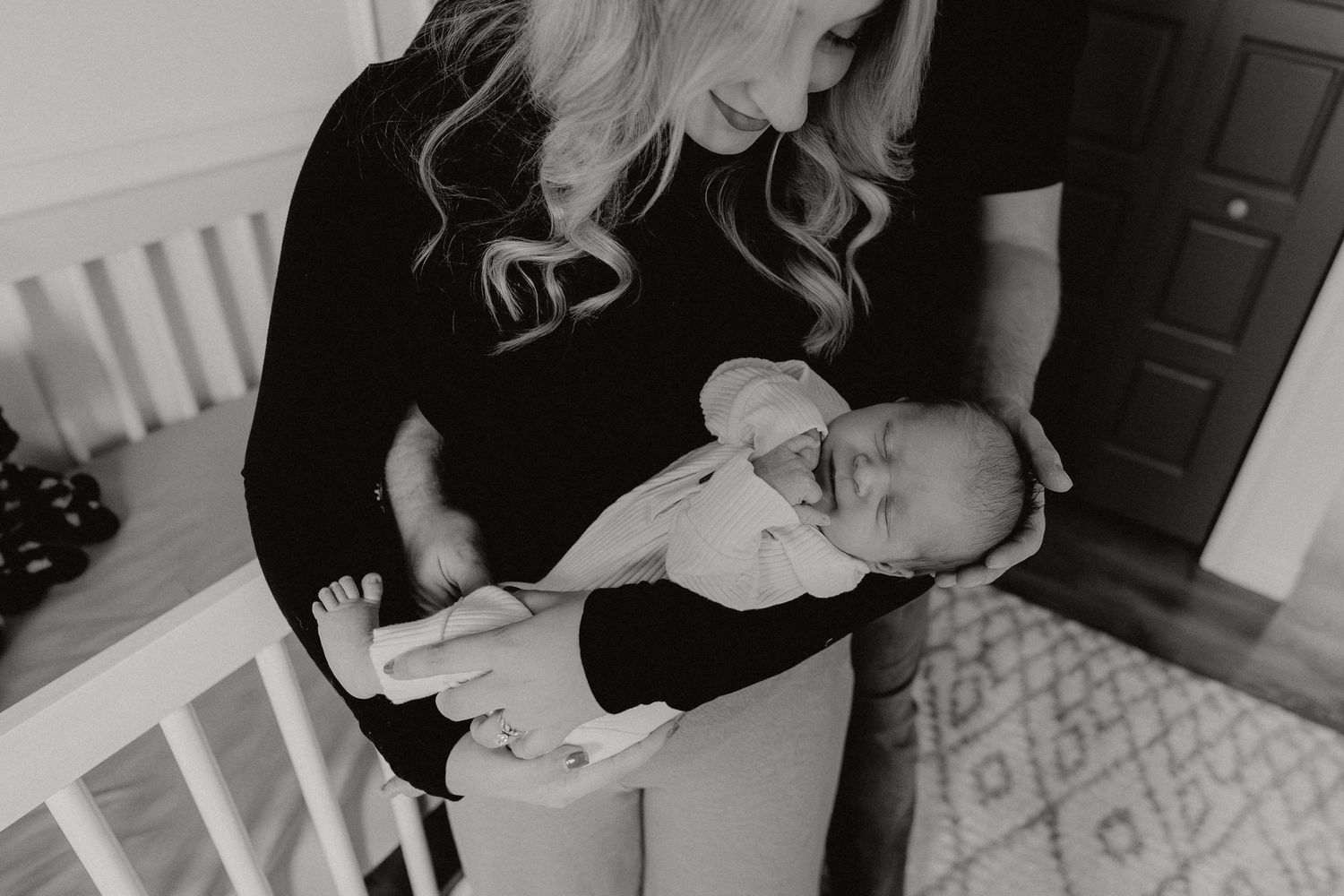 A nurturing scene in black and white showing a parent cradling a newborn.
