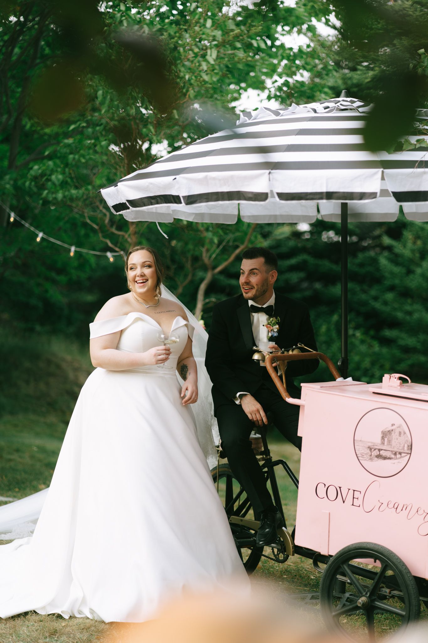 Outdoor wedding reception scene with white umbrellas and pink decor.